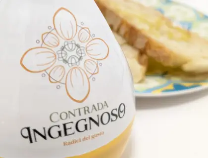 Bottiglia Contrada Ingegnoso e bruschetta su piatto di maiolica